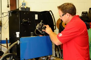 Man repairing welding equipment.